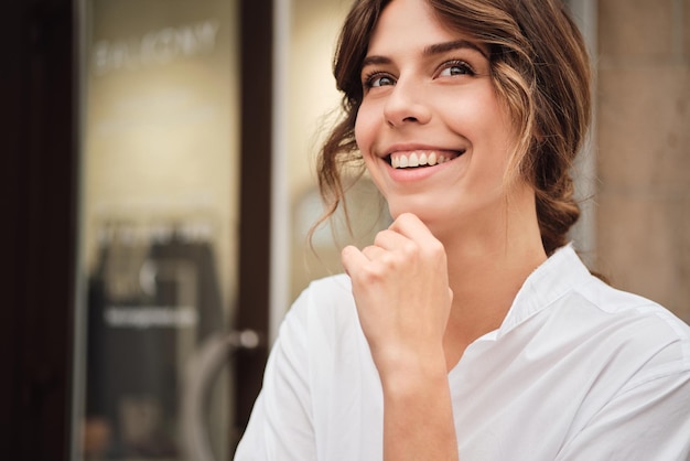 Portrait d'une jeune femme assez gaie qui regarde joyeusement dans un atelier moderne