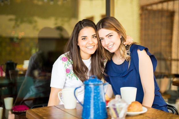 Portrait d'une jeune femme assise au café et établissant un contact visuel