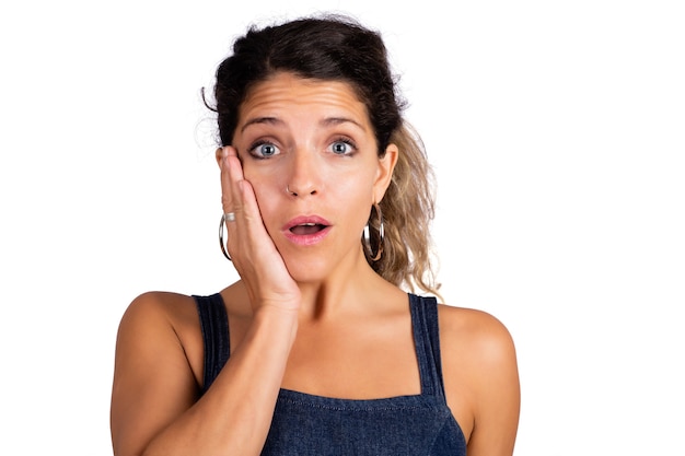 Portrait de jeune femme belle avec une expression choquée isolée sur fond blanc.