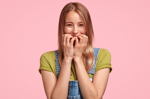 Portrait de jeune femme blonde portant une salopette en denim