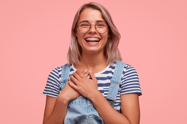 Portrait de jeune femme blonde portant une salopette en denim