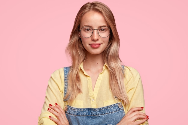 Portrait de jeune femme blonde en salopette en denim