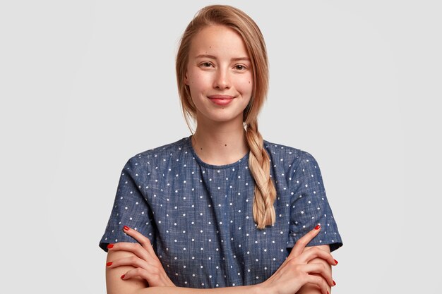 Portrait de jeune femme blonde avec tresse et chemisier à pois