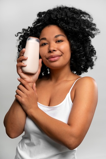 Portrait de jeune femme avec une bouteille de lotion pour le corps