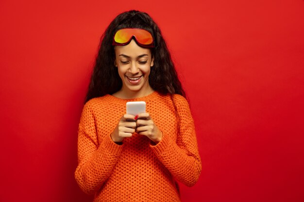 Portrait de jeune femme brune afro-américaine en masque de ski sur l'espace rouge