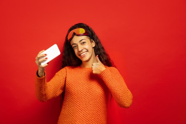 Portrait de jeune femme brune afro-américaine en masque de ski sur rouge