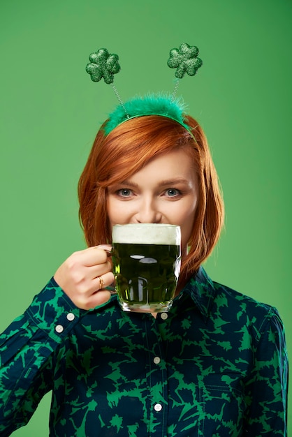 Portrait de jeune femme buvant de la bière