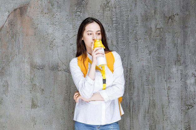 Portrait de jeune femme buvant une bouteille d'eau. Photo de haute qualité