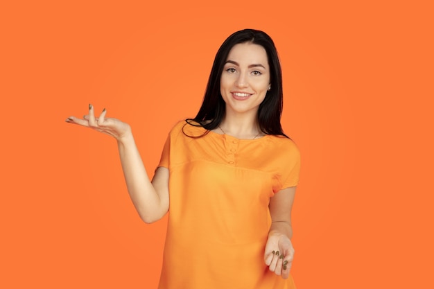 Portrait de jeune femme caucasienne sur fond orange