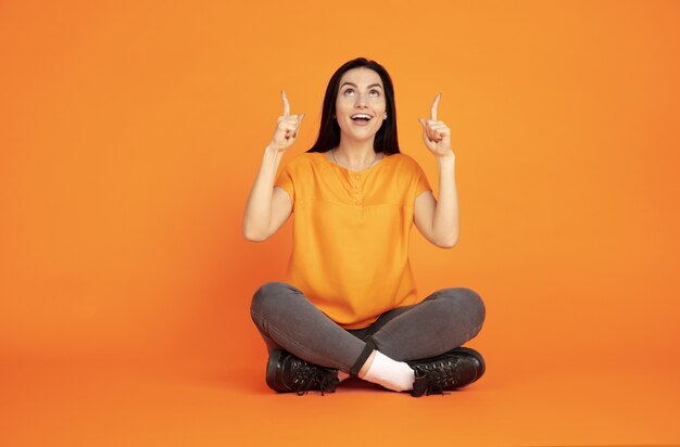 Portrait de jeune femme caucasienne sur orange