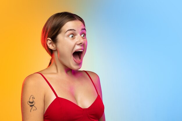 Portrait de jeune femme caucasienne sur studio dégradé en néon