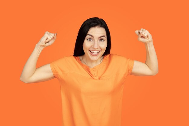 Portrait de jeune femme caucasienne sur studio orange