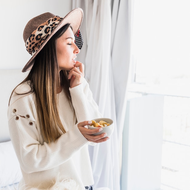 Portrait, de, jeune femme, chapeau, tenue, tenue, salade fruits, bol, regarder loin