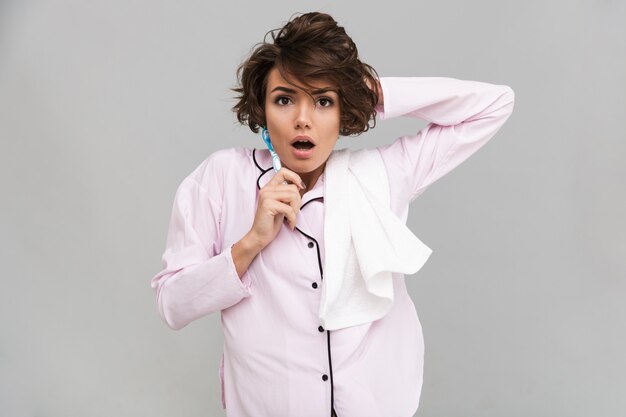 Portrait d'une jeune femme choquée en pyjama et serviette