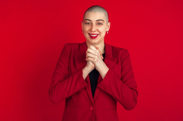 Portrait de jeune femme en costume rouge isolé sur studio rouge