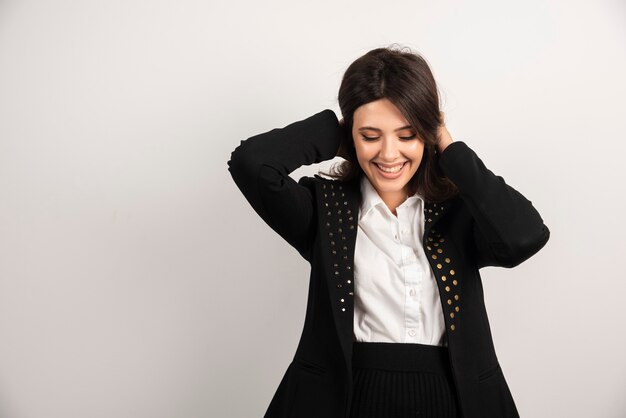 Portrait de jeune femme debout avec une expression heureuse.