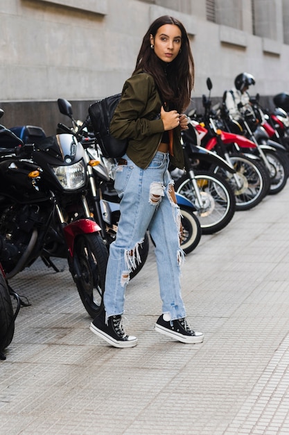 Portrait, jeune, femme, debout, stationnement, vélo, trottoir