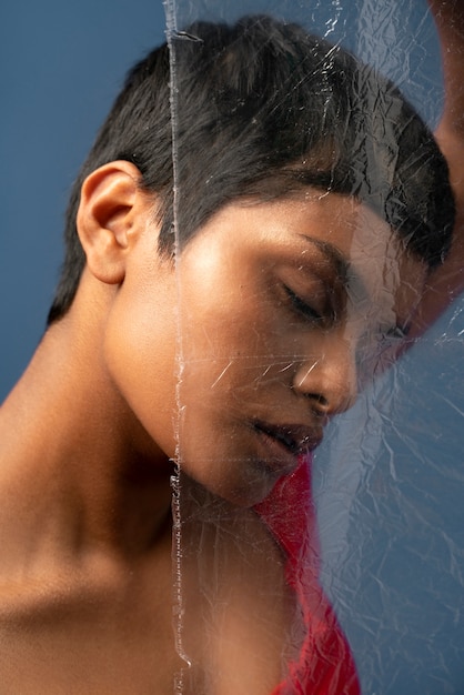 Portrait de jeune femme derrière une pellicule plastique