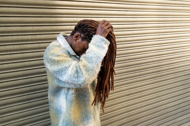 Portrait de jeune femme avec des dreadlocks afro exhibant ses cheveux en ville