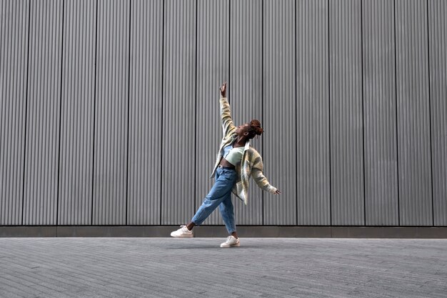 Portrait de jeune femme avec des dreadlocks afro posant en ville