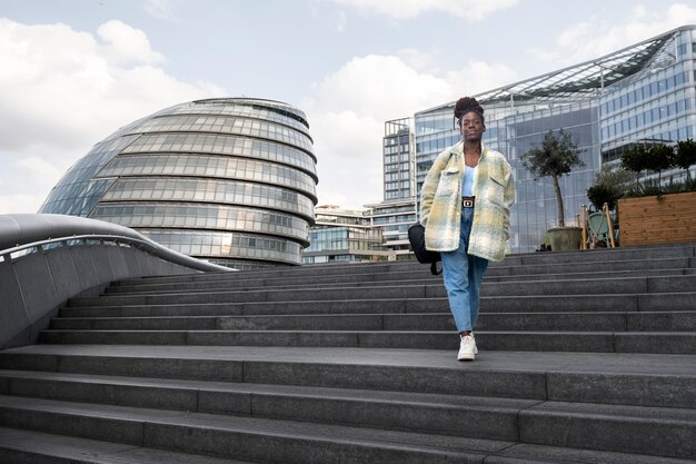 Portrait de jeune femme avec des dreadlocks afro et sac à dos dans la ville