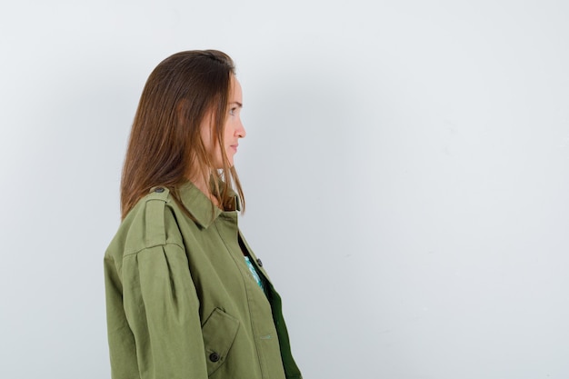 Portrait de jeune femme à l'écart, debout sur le côté en veste verte et à l'accent