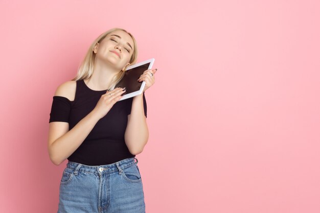 Portrait de jeune femme avec des émotions vives sur le mur de studio rose corail