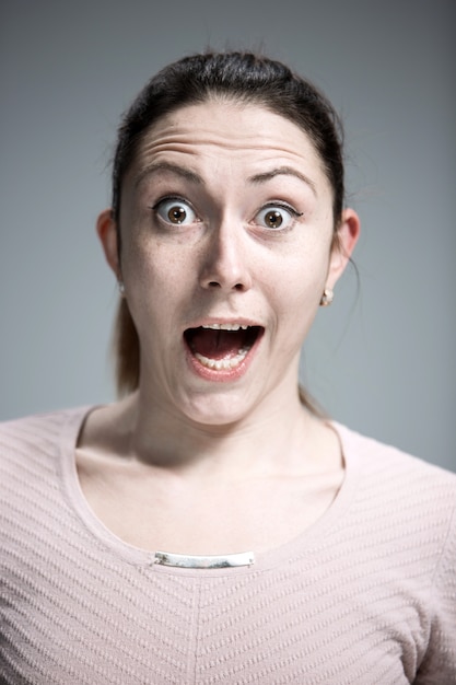 Portrait de jeune femme avec une expression faciale choquée