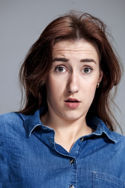 Photo gratuite portrait de jeune femme avec une expression faciale choquée