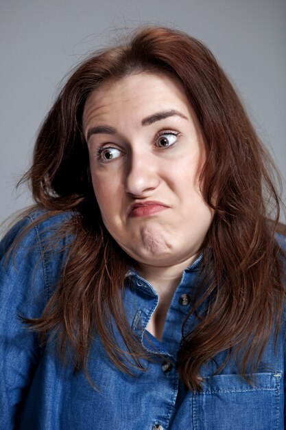 Portrait de jeune femme avec une expression faciale choquée