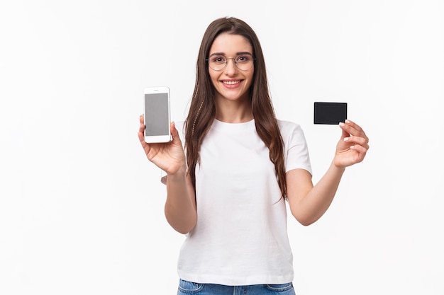 Portrait jeune femme expressive avec mobile et carte de crédit