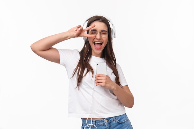 Portrait jeune femme expressive avec musique d'écoute mobile