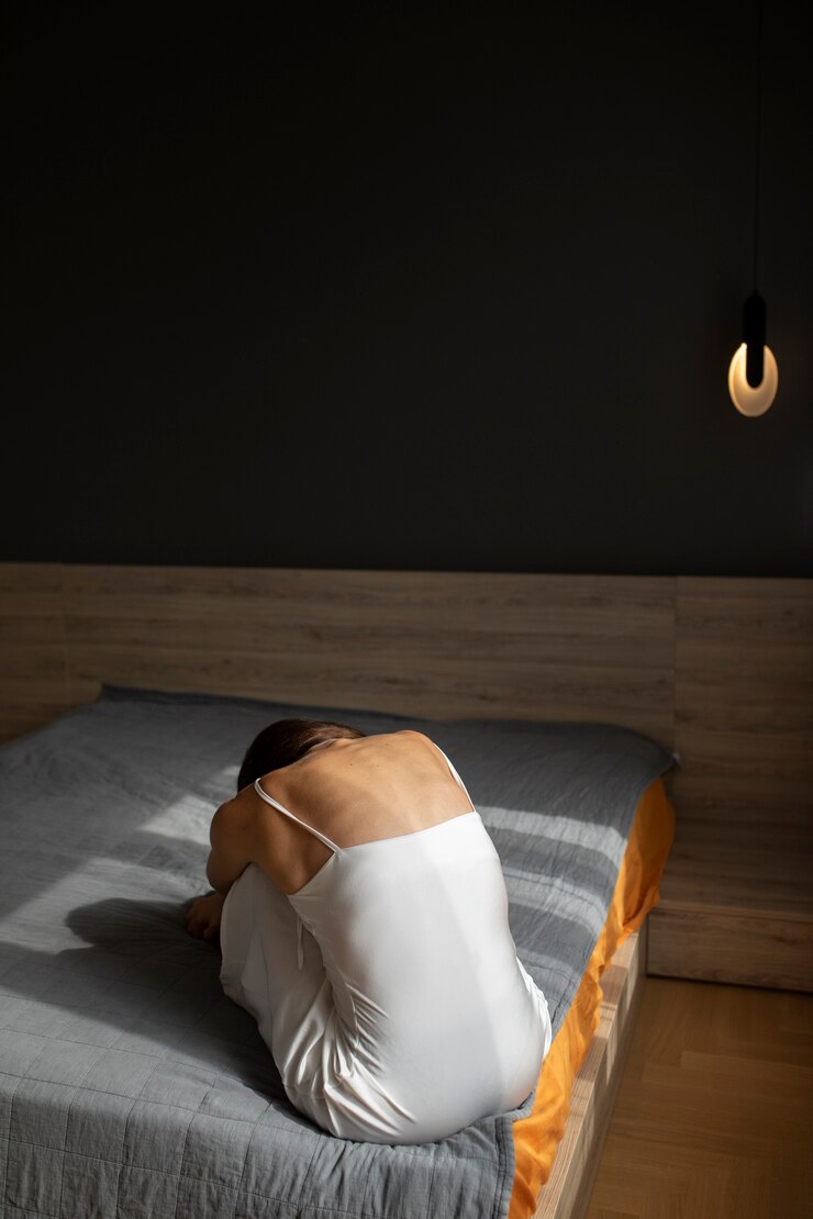 Photo gratuit portrait de jeune femme avec une faible estime de soi assis dans son lit à la maison