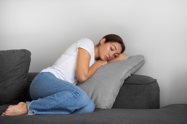 Portrait de jeune femme avec une faible estime de soi assise sur un canapé à la maison