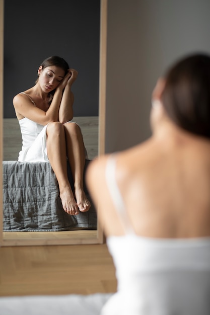 Photo gratuite portrait de jeune femme avec une faible estime de soi avec miroir