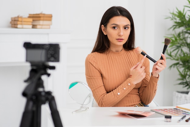 Portrait de jeune femme faisant son maquillage