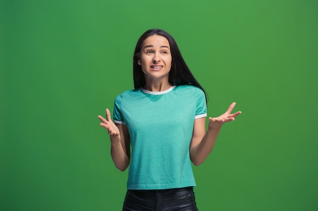 Portrait de jeune femme faisant valoir sur le mur vert