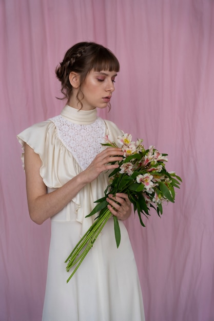 Portrait de jeune femme avec des fleurs vêtue d'une robe bohème chic