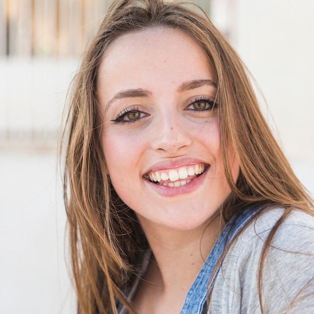 Photo gratuite portrait d'une jeune femme heureuse en regardant la caméra