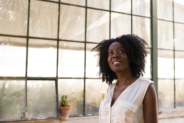 Portrait d&#39;une jeune femme heureuse regardant loin à l&#39;intérieur