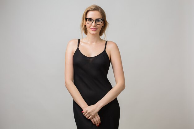 Portrait de jeune femme isolée sur blanc portant des lunettes dans une pose confiante et portant une robe noire