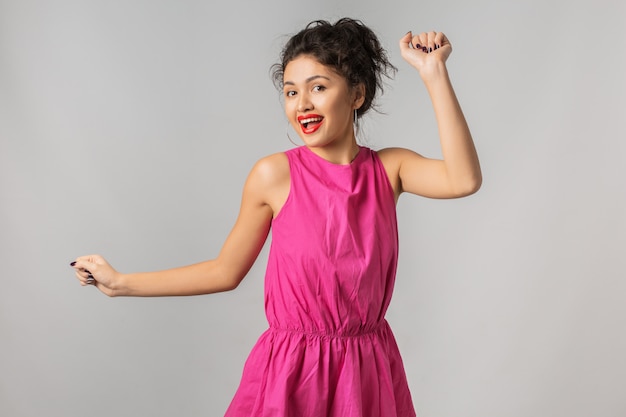 Portrait de jeune femme jolie positive en robe rose, danse, heureux, souriant, style d'été, rouge à lèvres, tendance de la mode, flirty`` asiatique, métisse, isolé