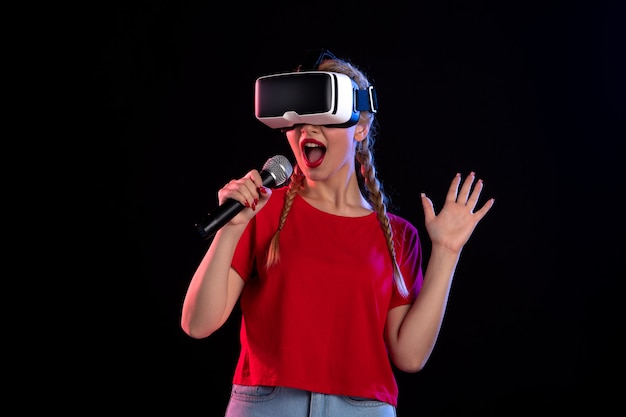 Photo gratuite portrait de jeune femme jouant à la réalité virtuelle et chantant sur un jeu visuel de musique sombre
