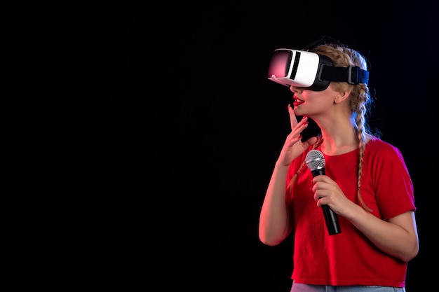 Portrait de jeune femme jouant à la réalité virtuelle et chantant sur un visuel de jeu d'ultrasons de musique sombre