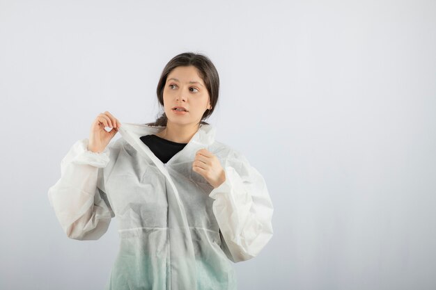 Portrait de jeune femme médecin scientifique en blouse de laboratoire défensive à l'écart.