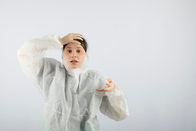 Portrait de jeune femme médecin scientifique en blouse de laboratoire défensive posant.