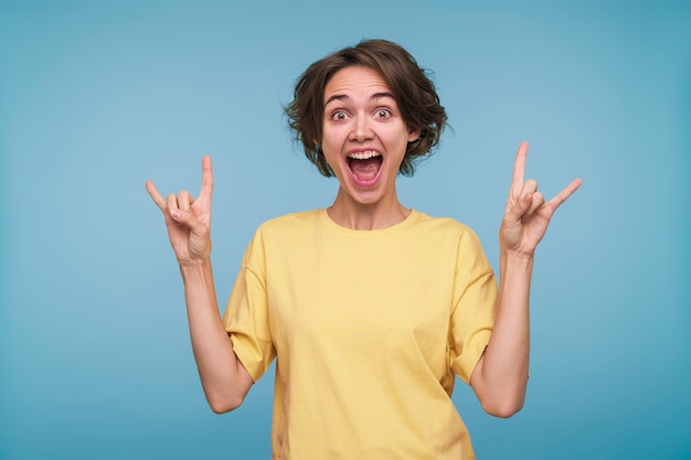 Portrait d'une jeune femme montrant le signe du rock and roll