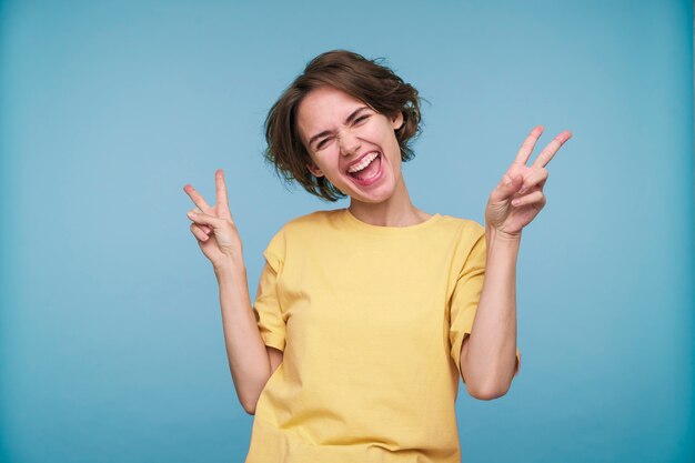 Portrait d'une jeune femme montrant le signe de la paix