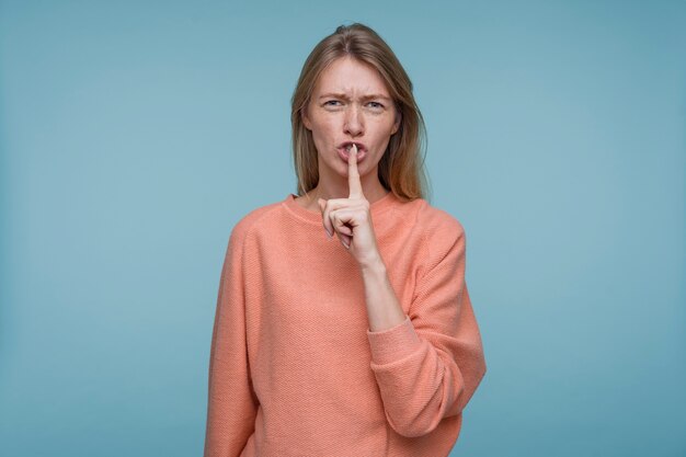 Portrait d'une jeune femme montrant le signe tranquille