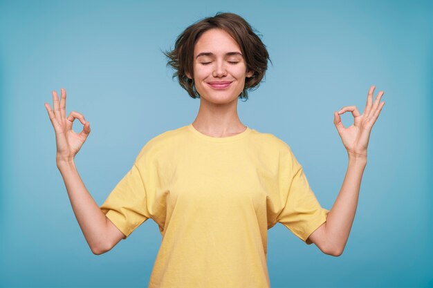 Portrait d'une jeune femme montrant le signe zen